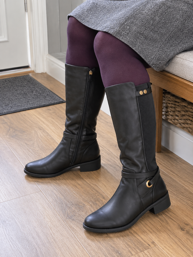 Black knee-high boots worn with a grey skirt and plum tights