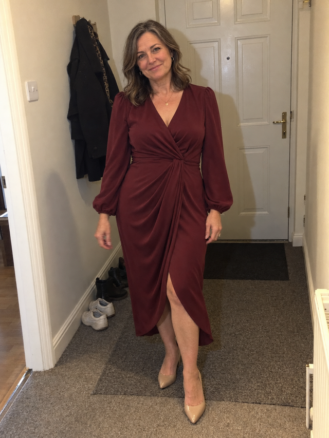 Woman in a burgundy evening maxi dress in her hallway, photographed with flash