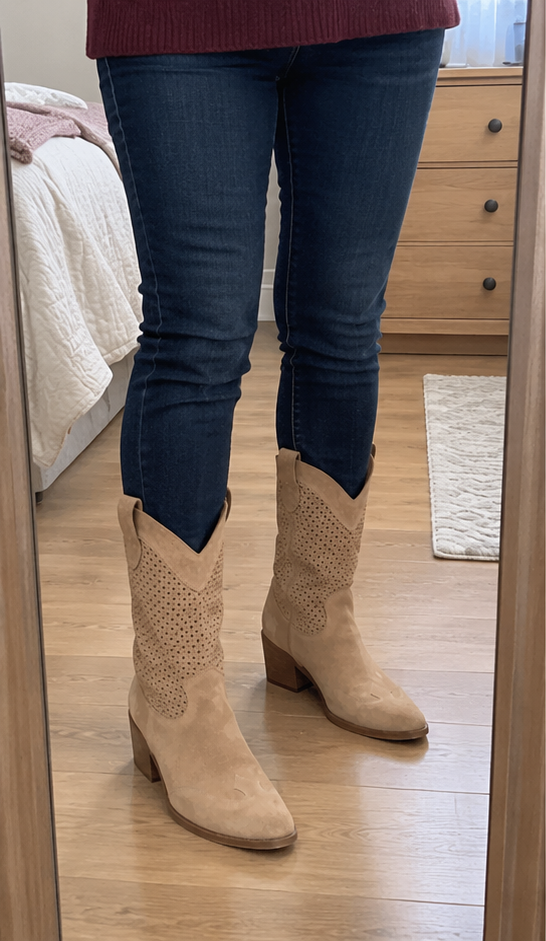 Brown western boots worn with jeans in a home mirror